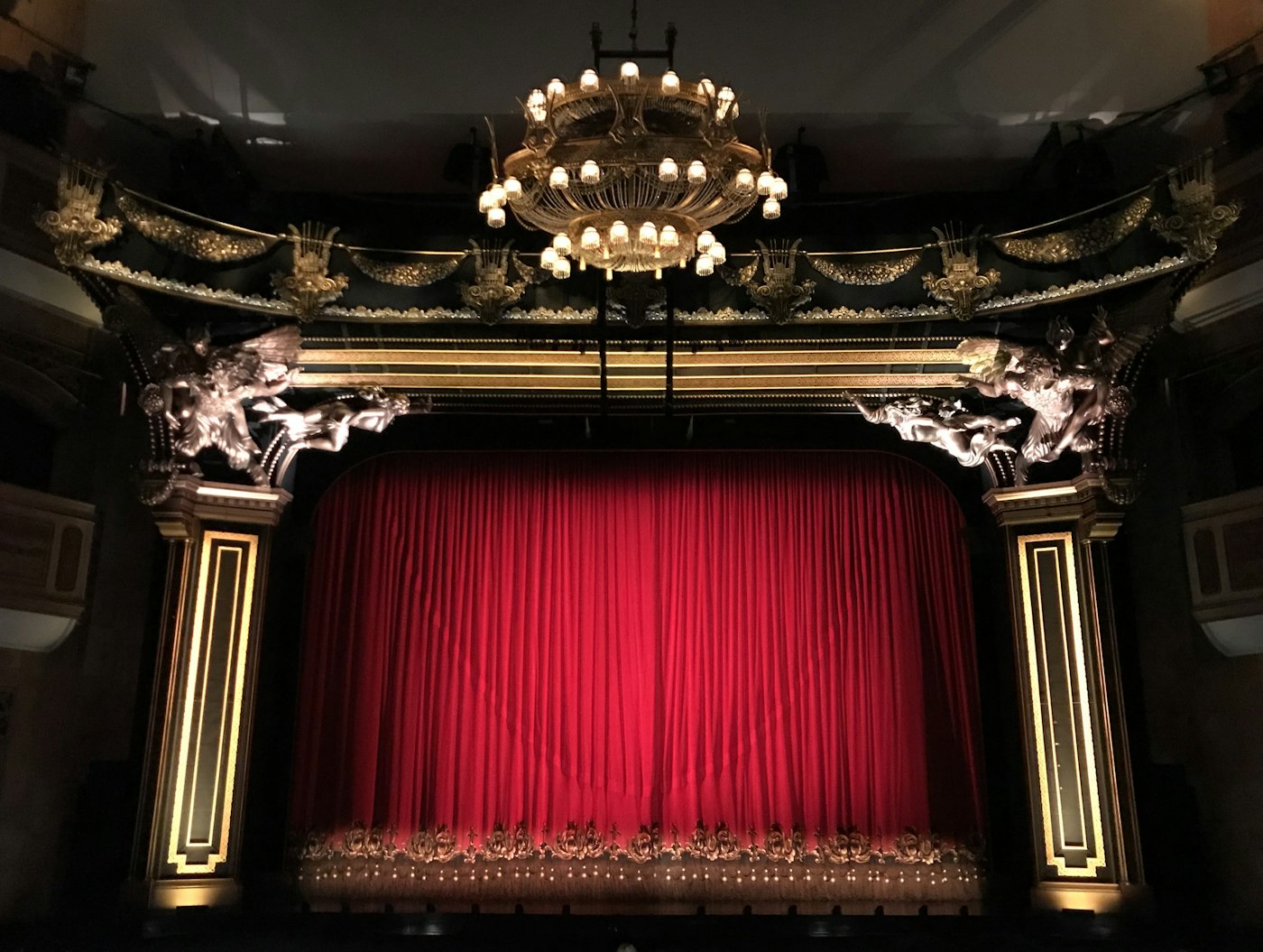 Silhouettes against a red theatre curtain